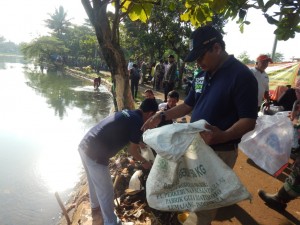 Kepala BLH Wijayanto turun langsung membersihkan sampah dipinggir setu Cilodong.(Dok SP)