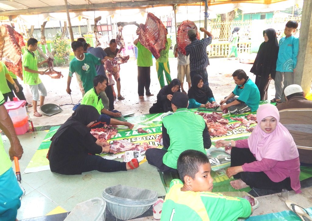 usai sapi dipotong para dewan guru terlibat panitia turut mengiris daging qurban yang akan disalurkan.